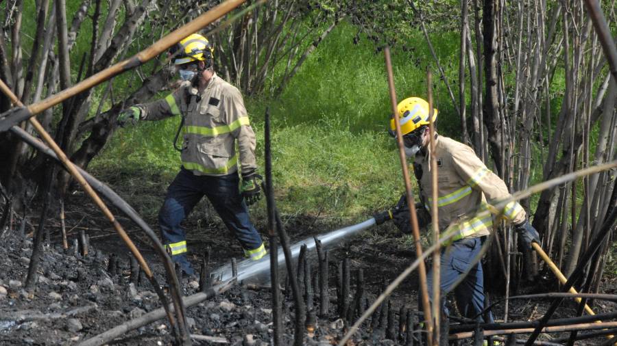 Dos bombers durant l'extinció avui de l'incendi de Valls. Foto: Àngel Juanpere