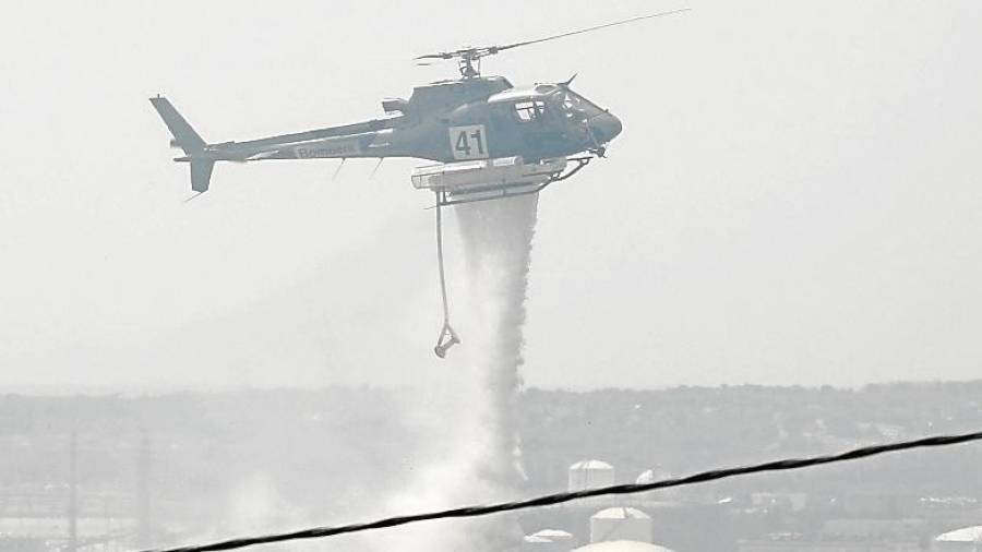 Un helicóptero descargando agua cerca de las casas. FOTO: Pere Ferré