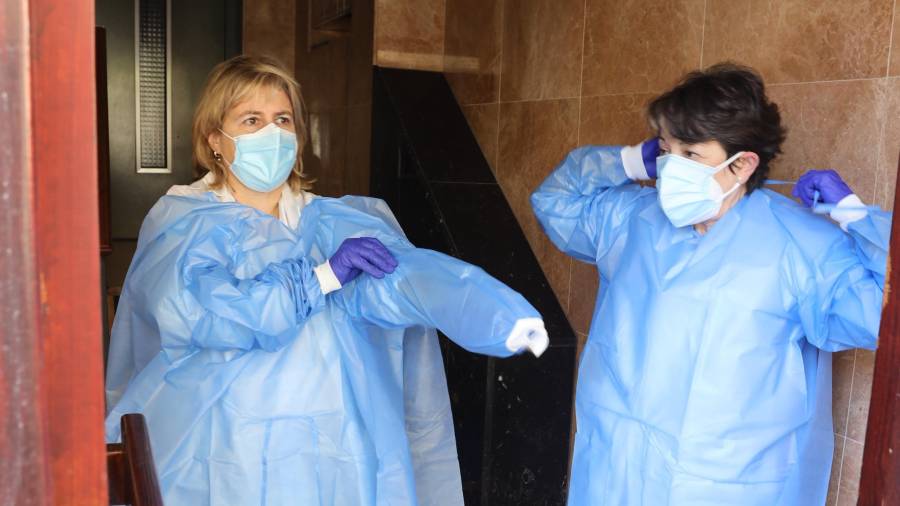 Dos enfermeras del CAP Llibertat de Reus se protegen antes de entrar a un domicilio. FOTO: ALBA MARINÉ