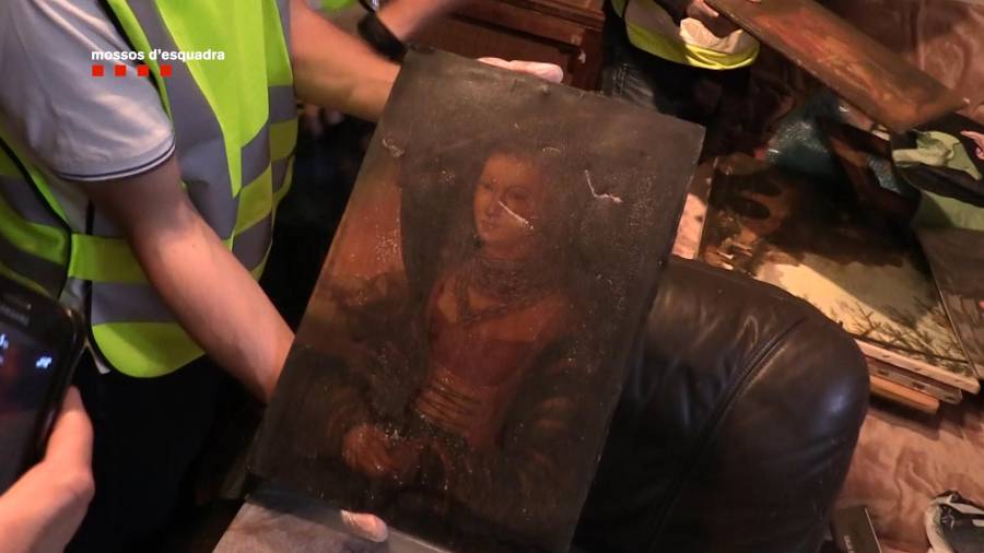 La policia intervenint una de les obres d'art robades pels detinguts.