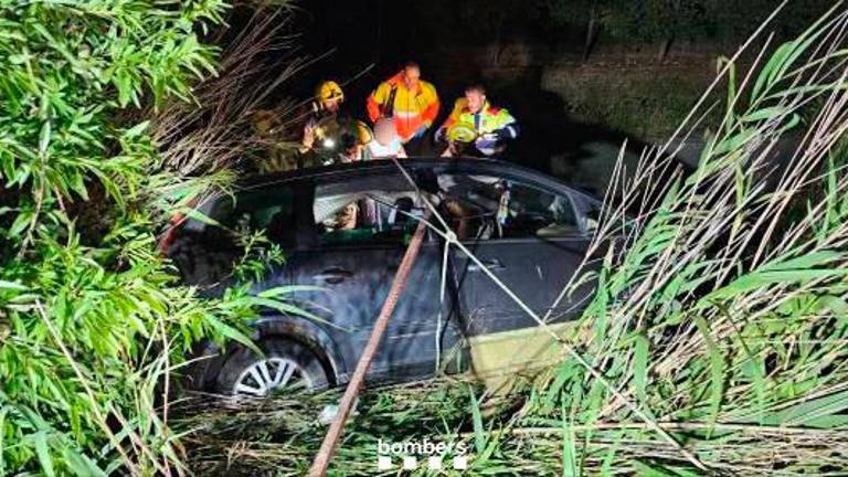 El coche accidentado y los bomberos trabajando. Foto: Bombers de la Generalitat