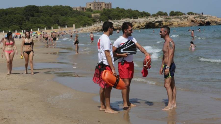 Dos socorristas dan indicaciones a un bañista en la Platja de l´Arrabassada. Foto: Lluís Milián
