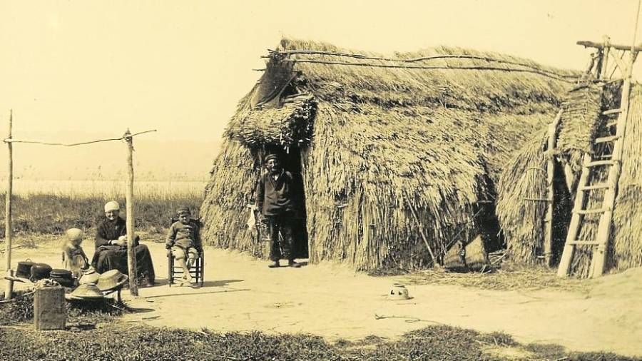 Una família davant d’una barraca tradicional al Delta de l’Ebre. FOTO: Arxiu Comarcal del Ripollès